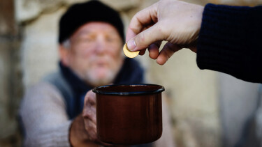 Person spendet Geld in Tasse