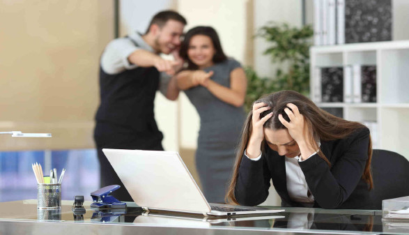 Frau wird im Büro von den Kollegen/-innen gemobbt